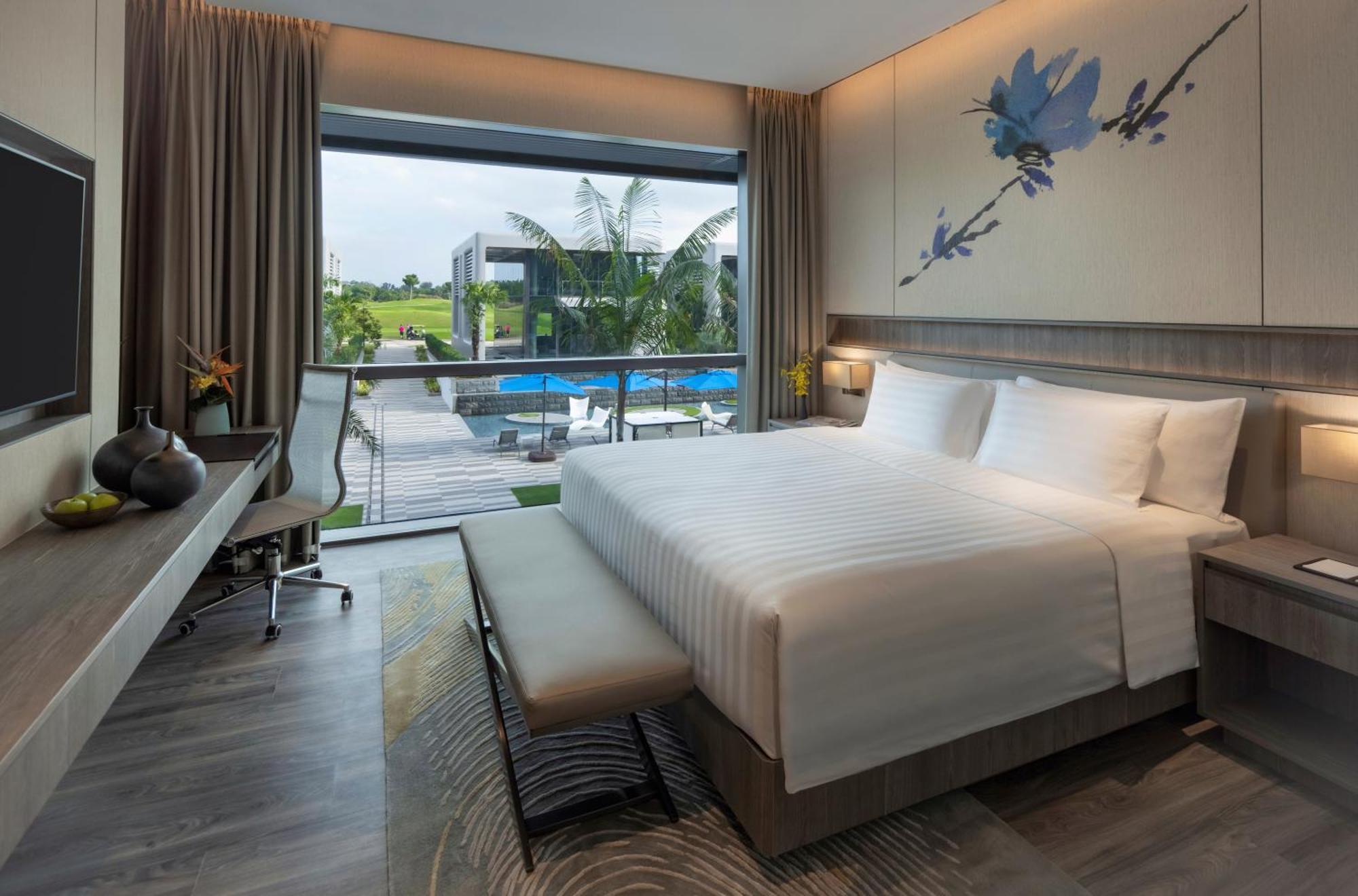 Dusit Executive Zimmer mit Kingsize-Bett und Poolblick